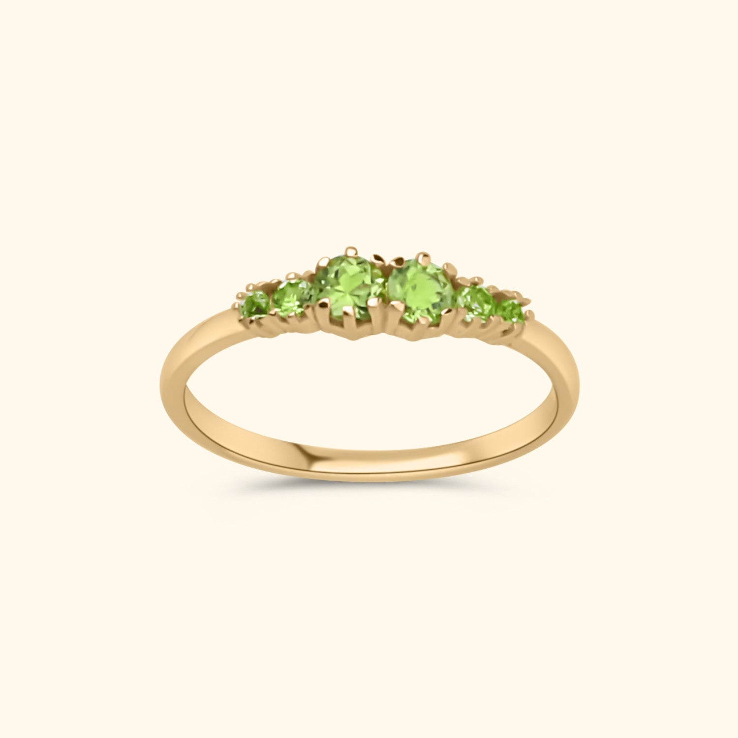 Goudkleurige ring met zes heldergroene peridot stenen in oplopende grootte, gezet in gold plated messing.